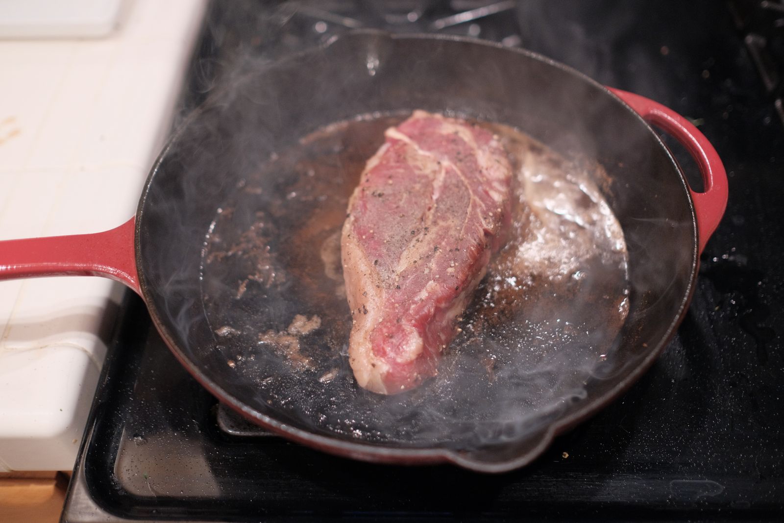 A step-by-step visual sequence showing cast iron seasoning: (1) a clean skillet being wiped with a thin coat of oil using a cloth; (2) the oiled skillet positioned upside-down on an oven rack with aluminum foil below to catch drips; (3) a close-up cross-section of the skillet surface showing multiple thin polymerized layers building up with each cycle; (4) a temperature gauge indicating 450–500°F; (5) a finished well-seasoned skillet with a dark, matte-black patina. Annotations label the oil thickness ("thin, nearly dry"), oven position ("upside down"), and the characteristic color progression from gray (bare iron) to dark black (fully seasoned).</illustrationAlt>
</invoke>