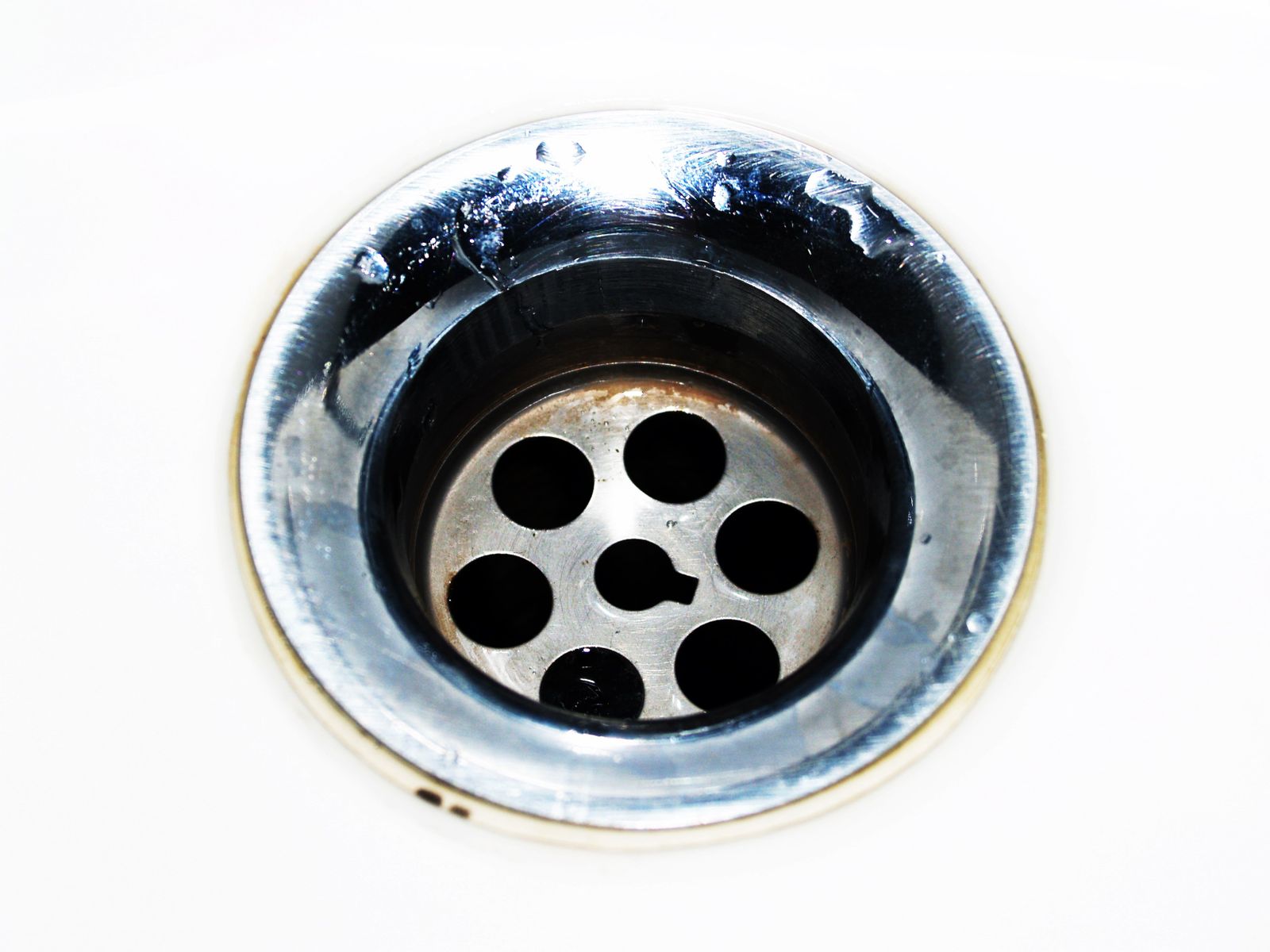 Cross-section diagram of a sink pipe system showing the P-trap, clog blockage, and placement of plunger and drain snake tools at key unclogging positions