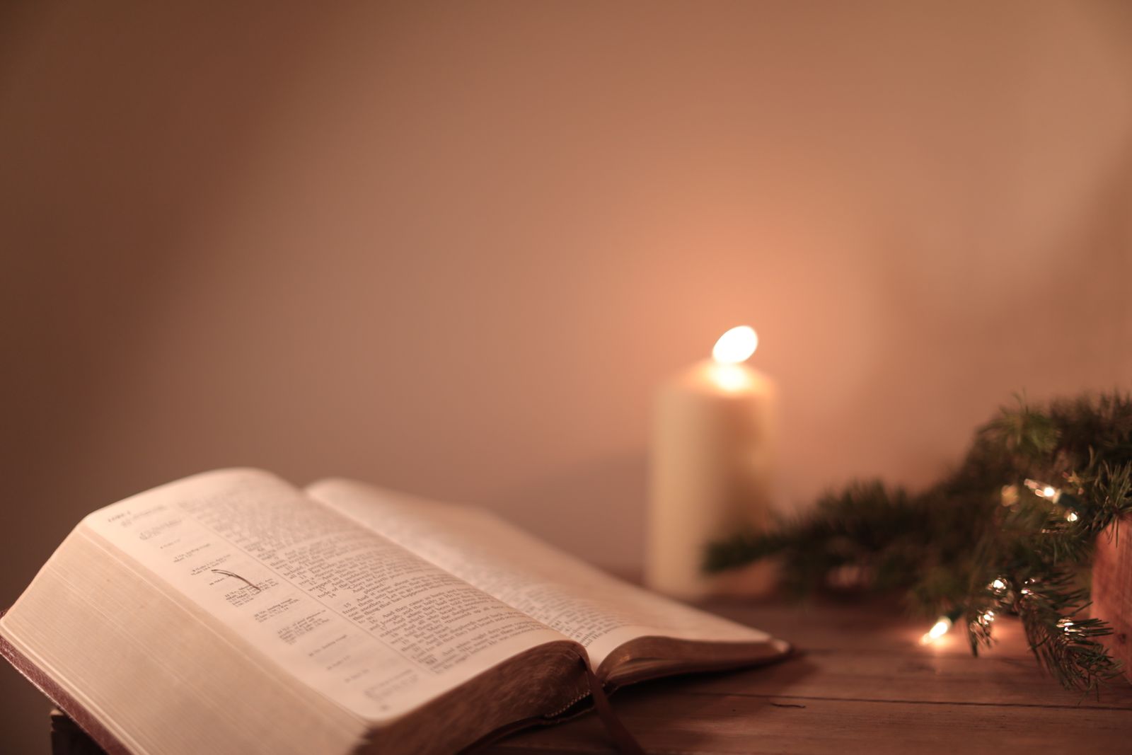 A man lying in bed at night in half-darkness, hands resting on his chest, with an open Bible on the nightstand and a faint glow of bedside light catching the edge of underlined passages—the moment of quiet prayer and reflection before sleep.